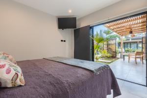 a bedroom with a large bed and a dining room at Zen Garden Tamarindo - Adults Only in Tamarindo