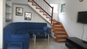a living room with a blue couch and a staircase at Apartments Ivanka Bilo in Primošten