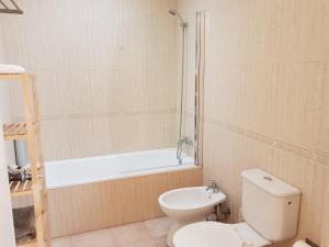 a bathroom with a toilet and a bath tub at A Casa Dos Amigos in Sesimbra +9 photos