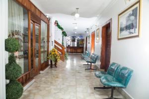 a corridor of a hospital with chairs and plants at Hotel Plaza del Teatro in Quito