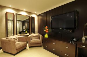 a living room with two chairs and a flat screen tv at The Golf Hotel Woodhall Spa in Woodhall Spa