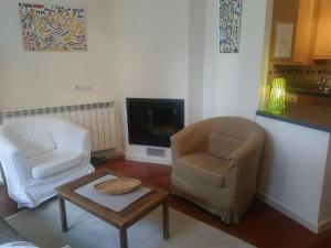 a living room with two chairs and a coffee table at ESQUI - PIRINEO DE HUESCA - GOLF & RELAX - VALLE de TENA in Sabiñánigo