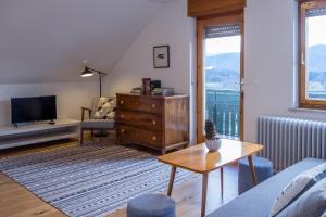 a living room with a couch and a tv and a table at HOMe apartments & Yoga studio in Bled-Rečica