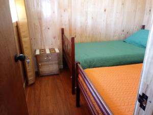 a room with two beds and a door to a room at CABAÑAS MAR BRAVA in Ancud