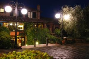 un patio iluminado por la noche con luces de la calle en Casanova - Wellness Center La Grotta Etrusca, en San Quirico dʼOrcia