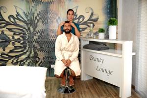 a woman standing behind a man in a spa room at Spa Residence Seibold in Waldkirchen