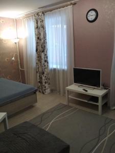 a bedroom with a bed and a desk with a television at Апартаменты на пр Александра Невского, 43 in Petrozavodsk