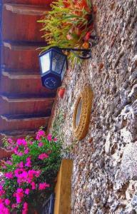 a street light on a stone wall with flowers at Hotel Posada San Jerónimo in Coatepec