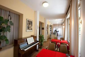 a room with a piano and a table and chairs at Albergo Moretti in Senigallia