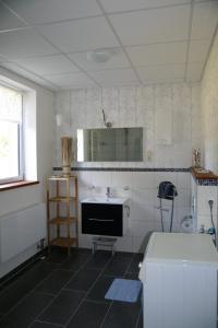 a white kitchen with a sink and a mirror at FeWo Vahls Mika in Elmenhorst