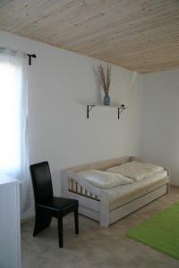 a bedroom with a bed and a chair in a room at FeWo Vahls Mika in Elmenhorst