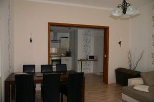 a dining room with a table and chairs and a living room at FeWo Vahls Mika in Elmenhorst