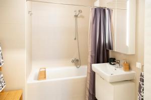 een witte badkamer met een wastafel en een douche bij Cozy & Cool Apartment * 5 Min to City Center in Wenen