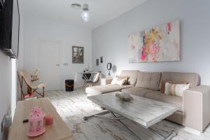 Sala de estar blanca con sofá y mesa en Mi Bohemia Caleta, en Cádiz