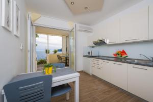 a kitchen with a desk and a table with a view of the ocean at Superb Beachfront Luxury Seaview with Private Beach in Hvar