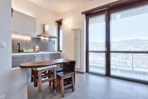 uma cozinha com uma mesa de madeira e uma grande janela em Attico Valentino Cellini em Turim