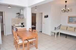 cocina y sala de estar con mesa de madera y sillas en Paradisia Villas en Naxos