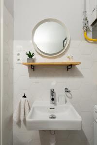 a bathroom with a white sink and a mirror at The Oktogon Executive Apartment in Budapest