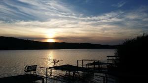 un tramonto su un lago con due barche in acqua di Napkelte Vendégház a Orfű