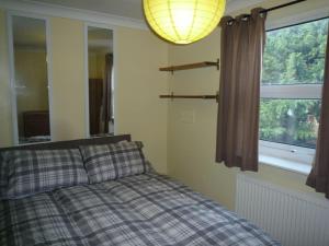 a bedroom with a bed and a window at Two Bedroom Flat St Andrews Road in London