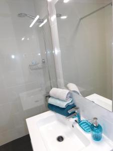 a bathroom with a sink and a shower with towels at LOLALAND in Morro del Jable +33 photos