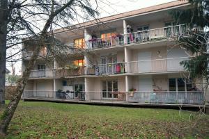 un immeuble d'appartements avec balcon et personnes sur le balcon dans l'établissement F1 entier Cosy style CHALET Montgeron, Proche Paris, à Montgeron