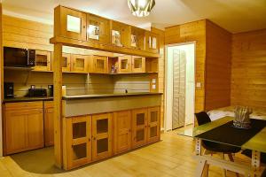 una cucina con armadi in legno, un tavolo e una sala da pranzo di F1 entier Cosy style CHALET Montgeron, Proche Paris a Montgeron
