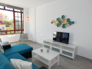a living room with a blue couch and a tv at LOLALAND in Morro del Jable