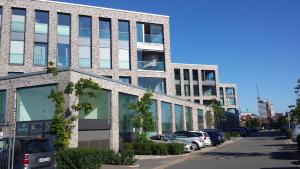 un bâtiment avec des voitures garées dans un parking dans l'établissement Ferienwohnung Romeike "NewPort", à Bremerhaven