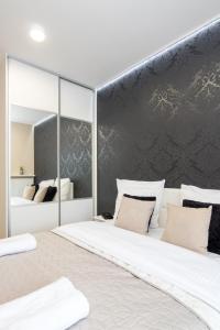 een slaapkamer met een groot bed en een grote spiegel bij Angel Apartament in Krakau