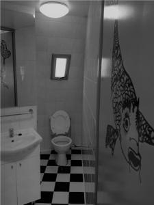 baño con aseo y cabeza de pescado en la pared en Iglo Bungalow 93, en Chaam