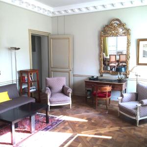 a living room with a mirror and a table and chairs at LOUVRE VENDOME with air conditionning in Paris