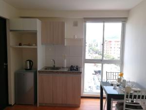 a kitchen with a table and a large window at Estudio Vacacional in Cochabamba