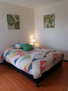 a bedroom with a bed with a colorful blanket at Estudio Vacacional in Cochabamba
