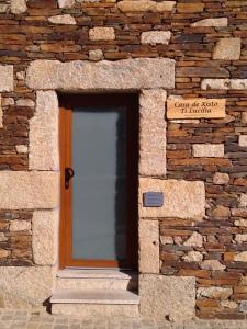 een stenen gebouw met een deur in een bakstenen muur bij Casa de Xisto Ti Lucília in Videmonte