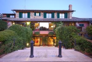 uma casa grande com um pátio em frente em Casanova - Wellness Center La Grotta Etrusca em San Quirico dʼOrcia