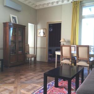 a living room with a couch and a table and chairs at LOUVRE VENDOME with air conditionning in Paris