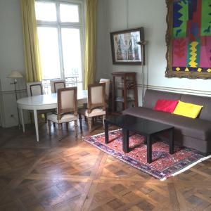 a living room with a couch and a table and chairs at LOUVRE VENDOME with air conditionning in Paris