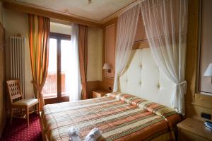Postel nebo postele na pokoji v ubytování Hotel Cristallo