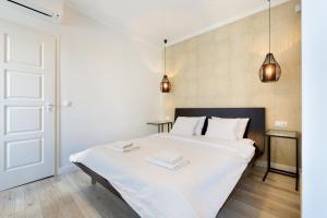 a bedroom with a white bed with two towels on it at Parlament Panorama Luxury Apartman in Budapest