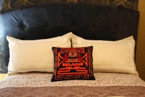 a pillow on a bed with two pillows at Boutique Amaru Wasi in Cusco