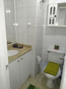 baño con aseo y lavabo con toalla verde en Departamento Santiago Centro Full Equipado, en Santiago