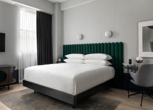 a bedroom with a large bed with a green headboard at Woodlark in Portland