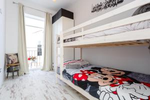 een slaapkamer met 2 stapelbedden met mickey muis lakens bij Mi Bohemia Caleta in Cádiz