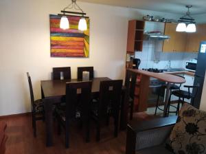 ein Esszimmer und eine Küche mit einem Tisch und Stühlen in der Unterkunft Apartamento Full Equipado Santiago Centro in Santiago