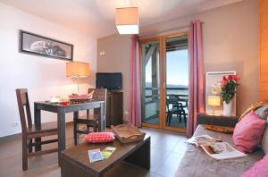 een woonkamer met een bank, een tafel en een bureau bij Résidence Le Pic de l'Ours in Font-Romeu