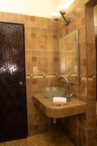 ein Bad mit einem Waschbecken und einem Spiegel in der Unterkunft Resort y Parque Acuatico Valle Dorado in El Rosario