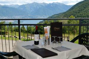 einen Tisch mit einer Flasche Wein und Gläsern in der Unterkunft Albergo Diana in Tronzano Lago Maggiore