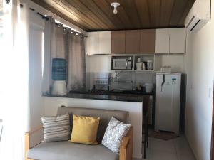 a kitchen with a couch with pillows on it at Chaleville Coqueiro 3802 in Luis Correia