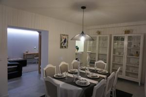 a dining room with a table with white chairs and a light fixture at House 41 in Vila Nova de Famalicão